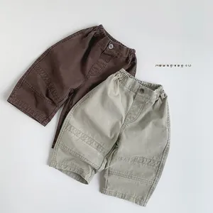 Detail view of elastic waist and decorative button on kids retro cotton cargo pants