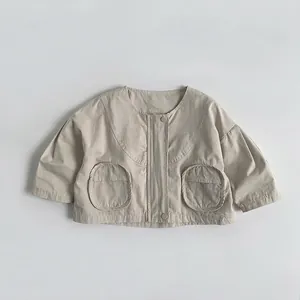 Detail view of neutral beige cotton kids jacket with large round patch pockets