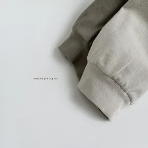 Detail view showing ribbed cuffs of children's cotton hoodies in dark green and grey colors
