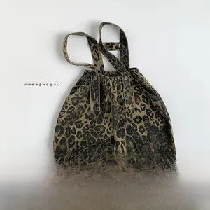 Detail view of leopard print kids overalls with adjustable straps and elastic waist