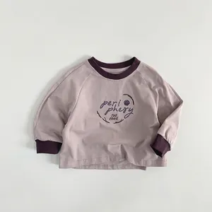 Détail des poignets côtelés et de l'impression artistique sur le sweat-shirt pour enfants