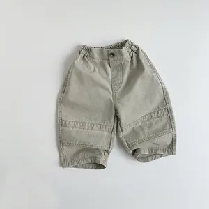 Close-up of children's khaki green cotton cargo pants with elastic waist and seam detail