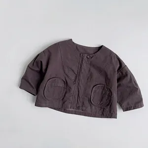 Detailed close-up of dark grey washed cotton kids jacket featuring large pockets and snaps