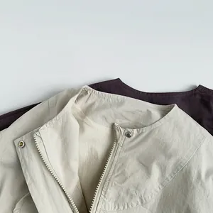 Detail of Korean style kids jacket with metal zipper and snap buttons in beige and brown
