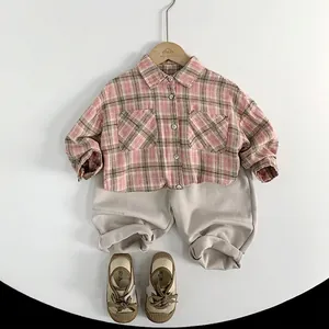 Kids plaid shirt set with pink checkered top, beige joggers and canvas shoes on white background