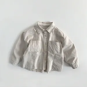 Détail de chemise en coton rayé pour bébé avec poches plaquées et fermeture boutonnée