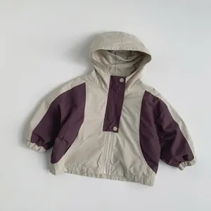 Detail of color-block kids hooded jacket with beige and purple拼接 and snap button closure