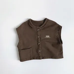 Détail du gilet marron pour enfant en coton avec bords francs et slogan imprimé