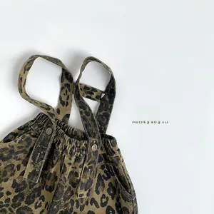Detail of children's leopard print overalls showing elastic waist and button texture