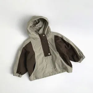 Detail of kids hooded windbreaker with khaki and brown color-blocking and zip closure