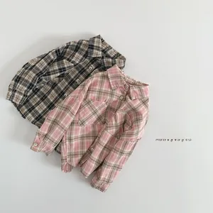 Detail view of plaid cotton shirts with classic collars and chest pockets for kids