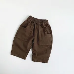 Detail of kids casual brown cotton pants featuring elastic waist and large side pockets