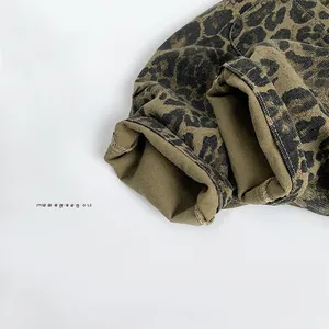 Close-up of leopard print toddler trousers showing cuffed hem and cotton twill texture