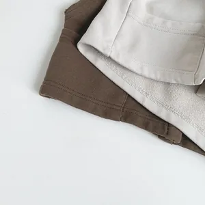 Détails macro de la couture et du tissu en maille sur les gilets marron et beige pour enfants