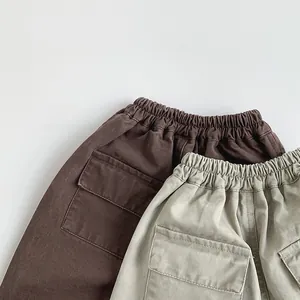 Detail of elastic waistband and decorative cargo flap pockets on toddler cotton pants