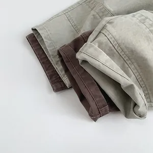 Detailed close-up of folded cotton pants cuffs in olive green, brown, and beige colors