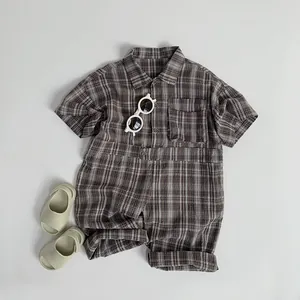 Detail of baby plaid romper with center buttons, chest pocket and natural cotton texture
