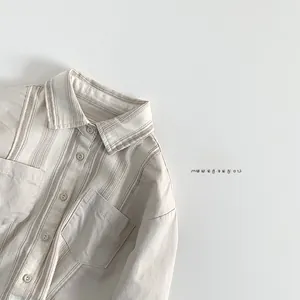 Détails d'une chemise rayée pour enfant en coton avec col classique et poches avant