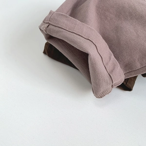 Detail of neatly stitched cuffs on pink and brown children's casual trousers