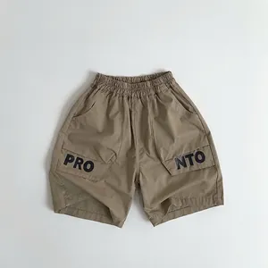 Detail of khaki cargo shorts with elastic waist and large side pockets for boys