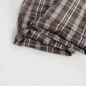 Classic brown checkered baby jumpsuit featuring rolled cuffs and soft cotton fabric