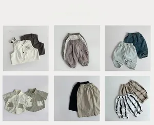 Close-up of assorted kids' cotton vests and shorts in beige, khaki, and navy earth tones