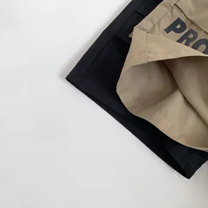 Detailed close-up of khaki and black patchwork kids pants featuring bold PRO letter print