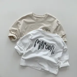 Detail of layered cotton t-shirts with MAROON print and folded cuffs for kids