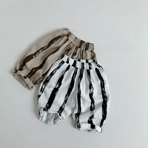 Détail du pantalon sarouel rayé en coton et lin avec taille et chevilles élastiques