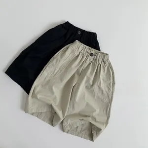 Detail of kids cotton linen shorts with elastic waistband and pockets in black and beige