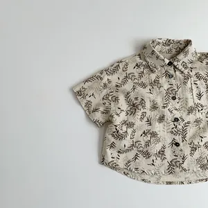 Detail of kids short sleeve shirt featuring dark brown floral print on cream cotton fabric