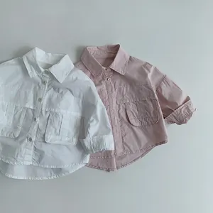 Mise à plat de chemises enfant en coton à manches longues en blanc et rose avec grandes poches