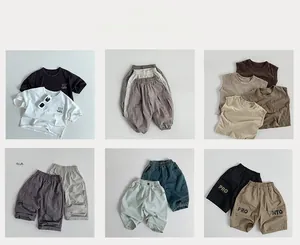 Flat lay of multiple summer outfit combinations featuring cotton t-shirts and cargo shorts