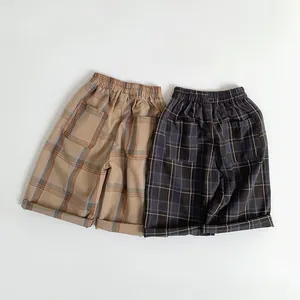 Detail of kids' elastic waist plaid shorts with back pockets and folded cuffs
