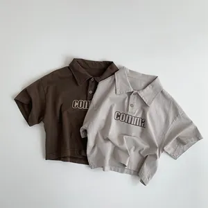 Vue détaillée de deux polos en coton marron et beige avec broderie sur la poitrine