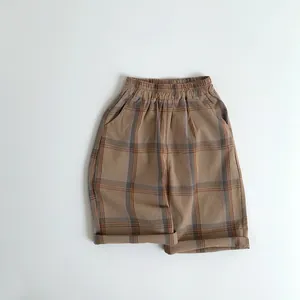 Detail of kids brown checkered shorts featuring elastic waist and cotton linen texture