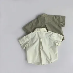Detailed back view of cotton short-sleeve shirts showing central box pleats in cream and green
