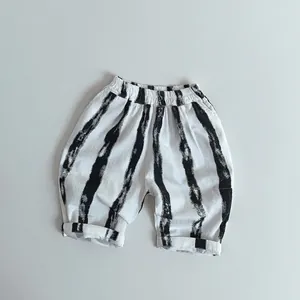 Détail du pantalon rayé ample pour enfants avec taille élastique et texture coton-lin