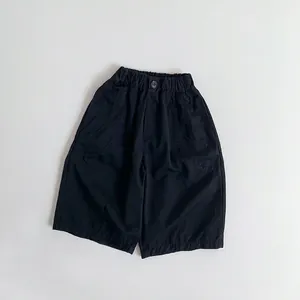 Detail of children's cotton pants showing elastic waistband, button, and breathable fabric