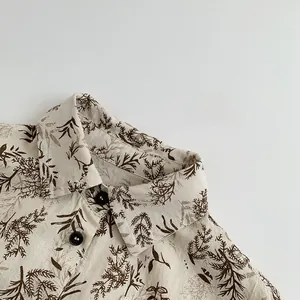 Close-up of retro cotton linen kids shirt with natural branch patterns and black buttons