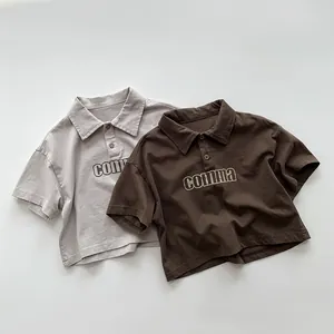 Détail à plat de polos en coton gris et marron avec imprimé de lettres comma