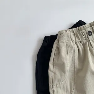 Macro shot of cotton kids pants showing elastic waistband with button and fabric texture