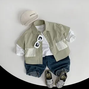 Flat lay of boys short-sleeved green shirt with white T-shirt and denim shorts set
