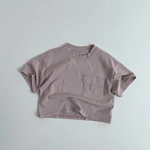 Détail d'un t-shirt enfant en coton rose poudré avec une poche poitrine cargo stylée