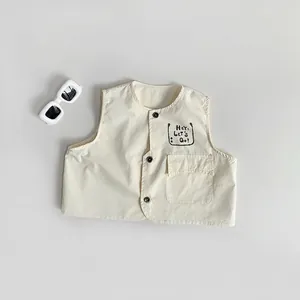 Detailansicht der beigen Baumwoll-Kinderweste mit Print und dunklen Knöpfen
