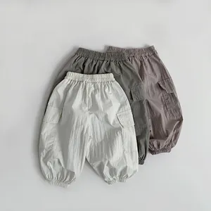 Detail of lightweight kids cargo pants showing soft textures and elastic cuffs in three colors