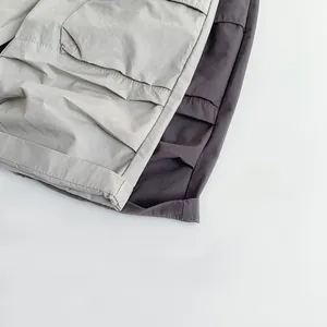 Detailed view of light and dark grey kids cotton trousers with cargo pockets and clean seams