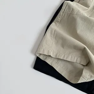 Detail view of cotton casual pants for kids in beige and black with soft texture