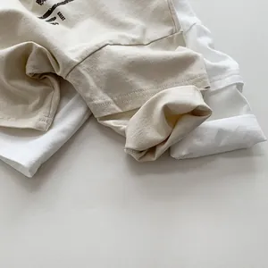 Detail view of cotton long-sleeve shirts showing fine stitching and beige knit fabric