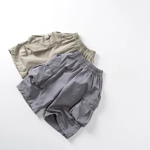 Détail du short cargo enfant avec taille élastique et poches latérales en kaki et gris